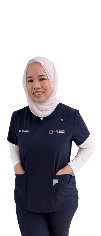 Smiling female doctor in a hijab and blue scrubs with hands in pockets.